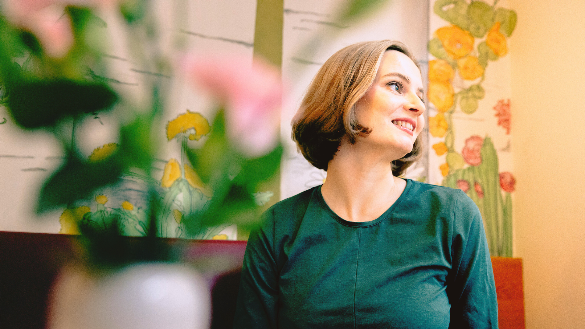 Anni Paananen oululaisessa kahvila Puistolassa kukkien keskellä